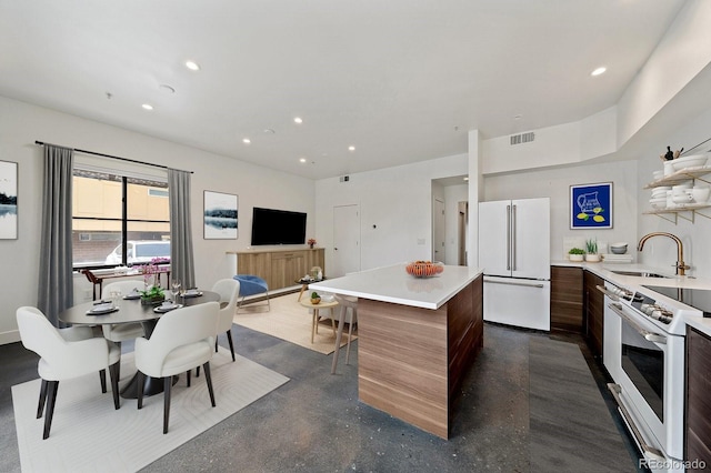 kitchen with white appliances, a center island, and sink