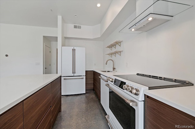 kitchen with dark brown cabinetry, white appliances, sink, and range hood