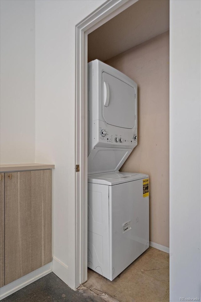 washroom with tile patterned floors and stacked washer and clothes dryer