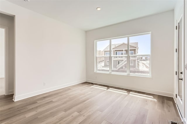 unfurnished room featuring wood finished floors, baseboards, and recessed lighting
