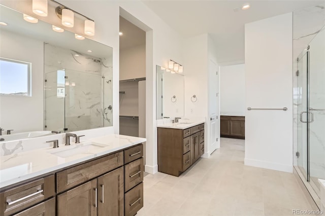 full bath featuring a marble finish shower, two vanities, baseboards, recessed lighting, and a spacious closet