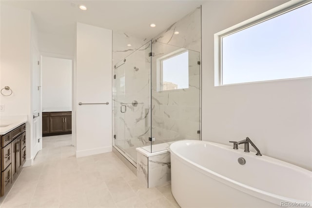 bathroom featuring a marble finish shower, vanity, a freestanding bath, and recessed lighting
