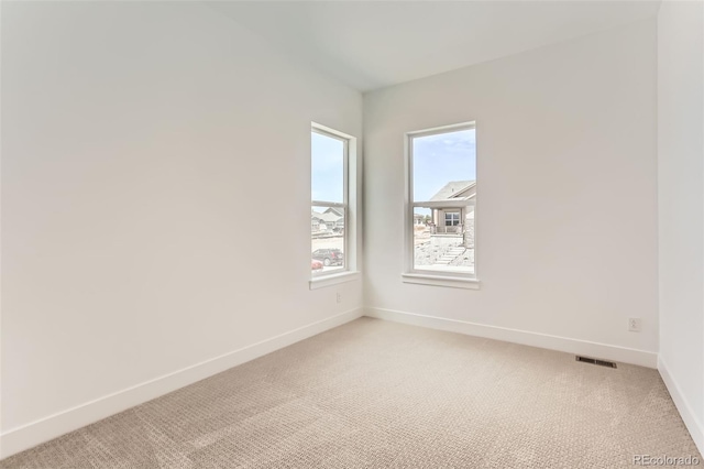unfurnished room featuring baseboards and light colored carpet