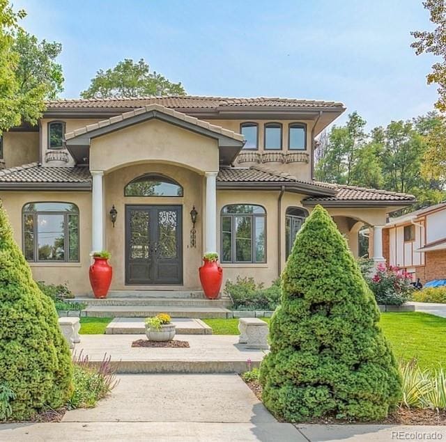 property entrance with a tile roof and stucco siding