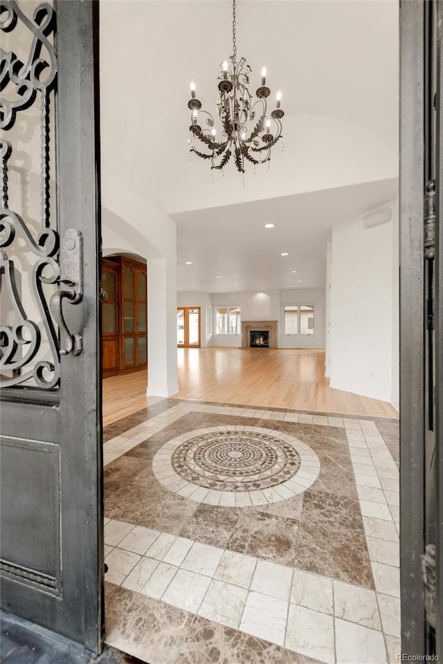 foyer featuring arched walkways, a notable chandelier, recessed lighting, and a high ceiling