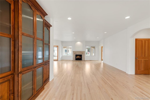 unfurnished living room with light wood-style flooring, recessed lighting, and a lit fireplace