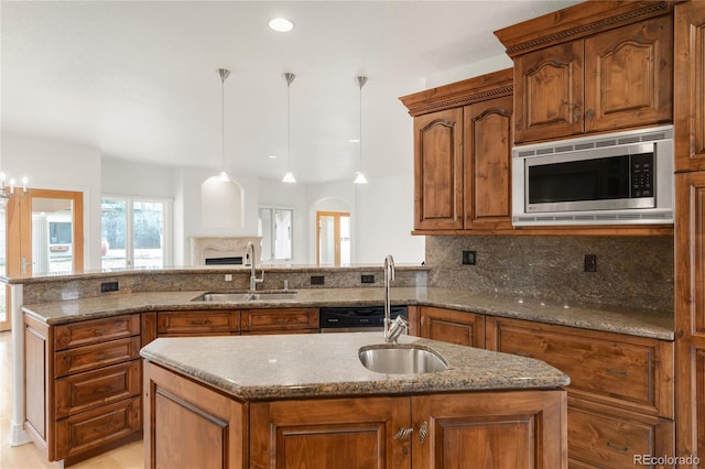 kitchen with stainless steel microwave, brown cabinets, and a sink