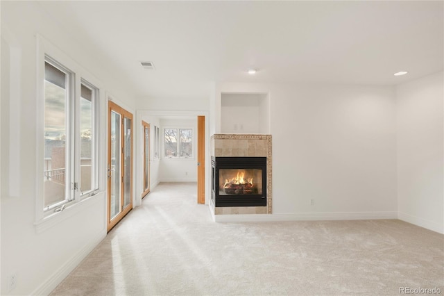 unfurnished living room featuring visible vents, a tiled fireplace, recessed lighting, carpet floors, and baseboards