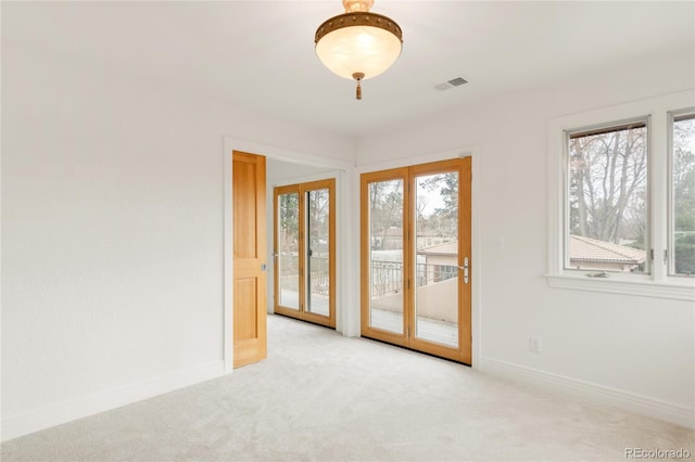 carpeted spare room with baseboards and visible vents