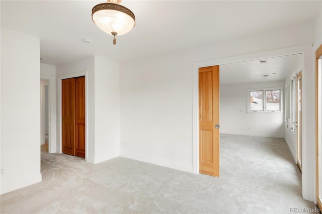 carpeted spare room featuring baseboards