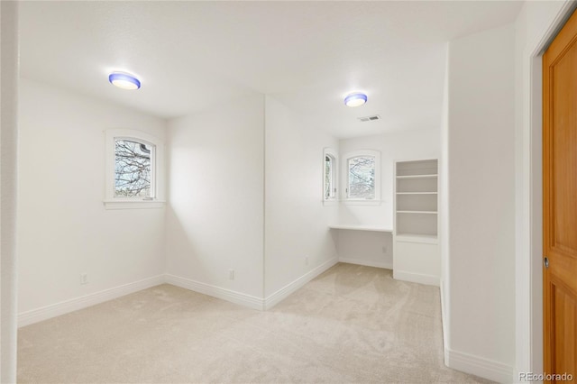 interior space with visible vents, plenty of natural light, and light colored carpet