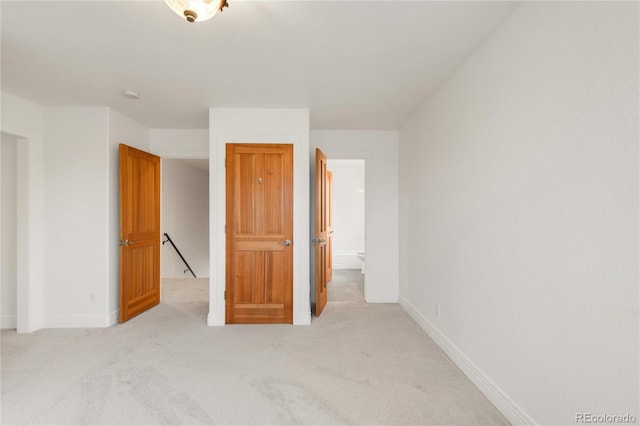 unfurnished bedroom featuring light colored carpet and baseboards