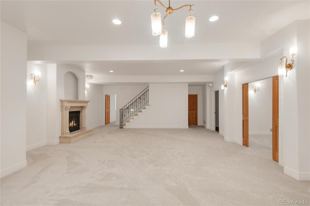 below grade area featuring stairway, baseboards, a fireplace, recessed lighting, and light carpet