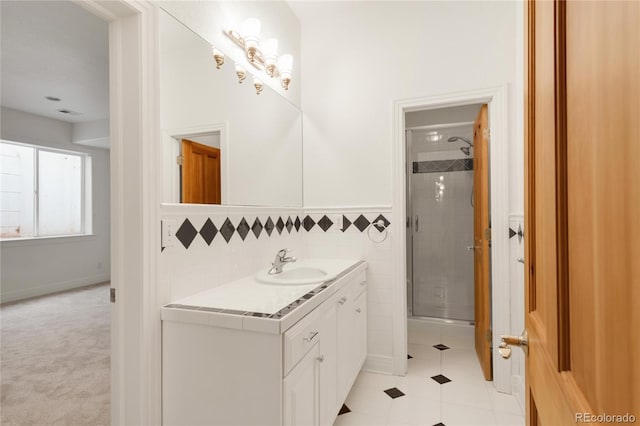 bathroom with tile patterned flooring, a stall shower, vanity, and tile walls