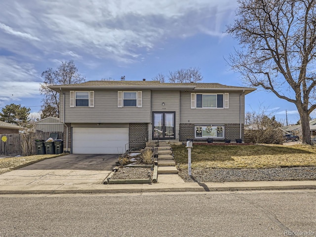 bi-level home featuring brick siding, driveway, and an attached garage