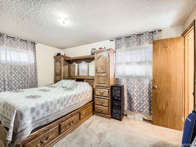 bedroom with a textured ceiling and light colored carpet