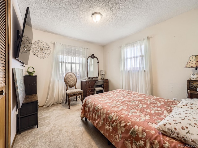 bedroom with light colored carpet and a textured ceiling