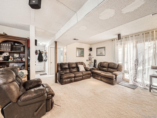 carpeted living area with visible vents and a textured ceiling