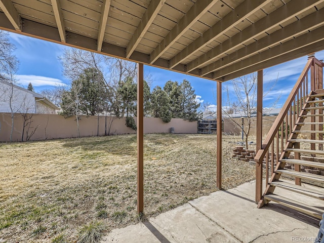 view of yard with a patio area, a fenced backyard, and stairway