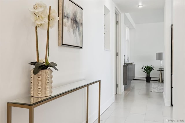 hallway featuring baseboards and light tile patterned floors