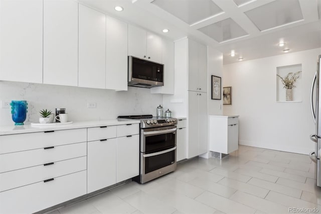 kitchen with stainless steel appliances, recessed lighting, light countertops, backsplash, and white cabinets