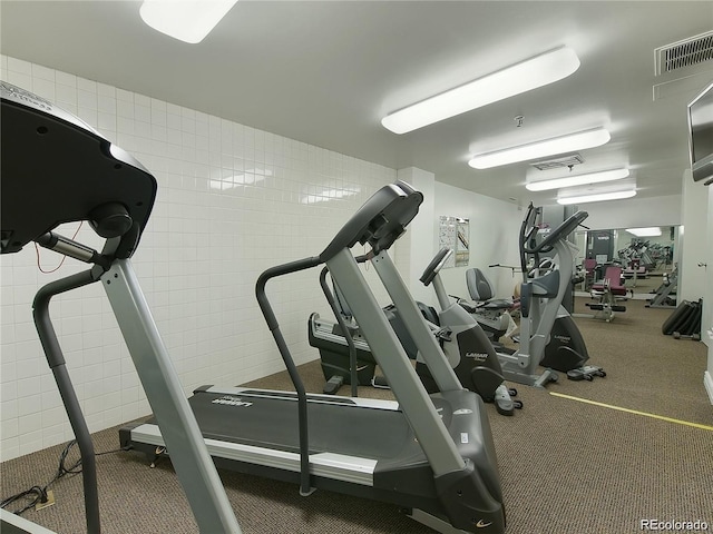 gym with visible vents and tile walls