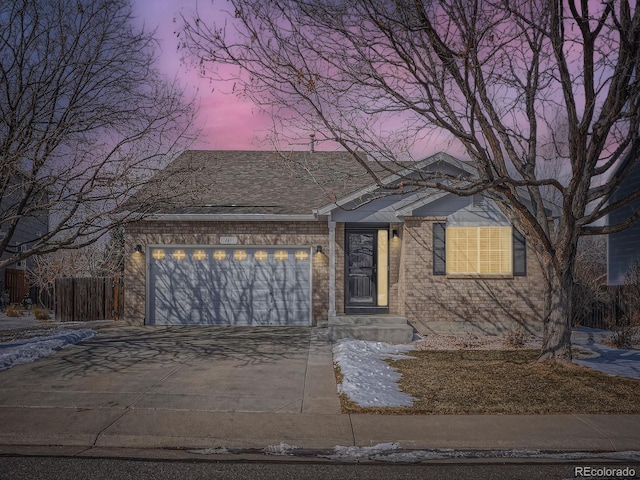 view of front of home featuring a garage, concrete driveway, and brick siding