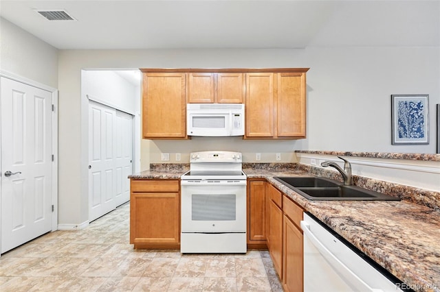 kitchen featuring white appliances, visible vents, and a sink