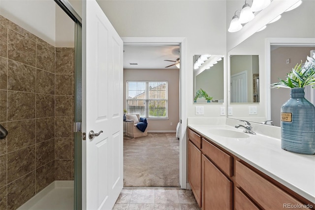 bathroom featuring ceiling fan, vanity, tile patterned floors, baseboards, and a shower stall