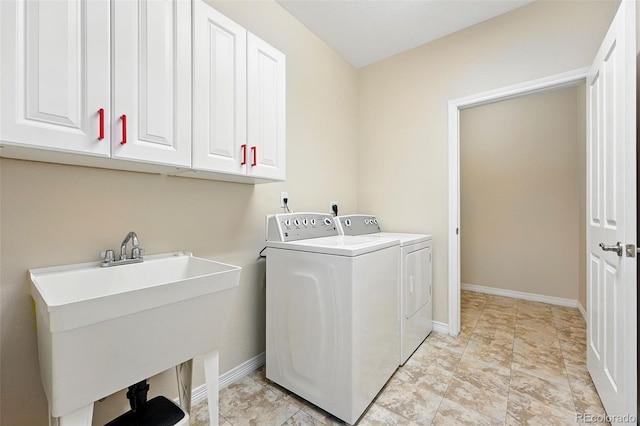 laundry room with a sink, washer and clothes dryer, cabinet space, and baseboards