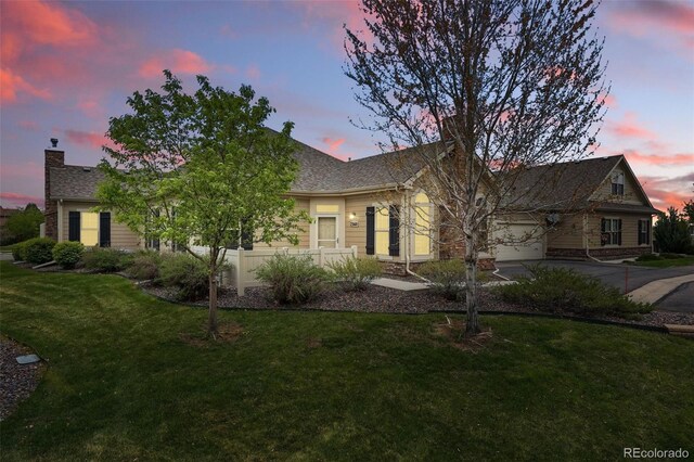 single story home featuring a garage, a lawn, a chimney, and concrete driveway