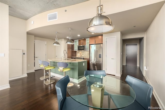 dining space with sink and dark wood-type flooring