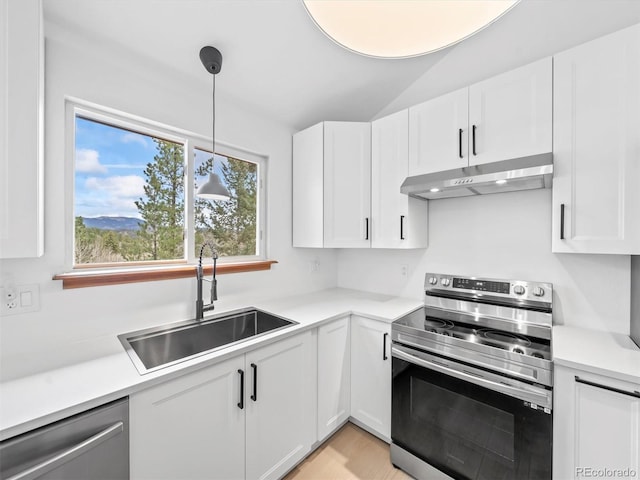 14 Aspen Dr, Bailey, CO 80421 - kitchen featuring stainless steel appliances, under cabinet range hood, a sink, white cabinets, and vaulted ceiling