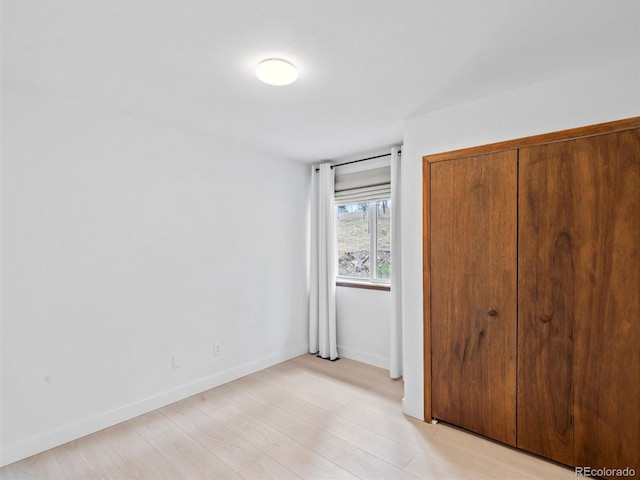 14 Aspen Dr, Bailey, CO 80421 - unfurnished bedroom featuring light wood-style flooring, baseboards, and a closet