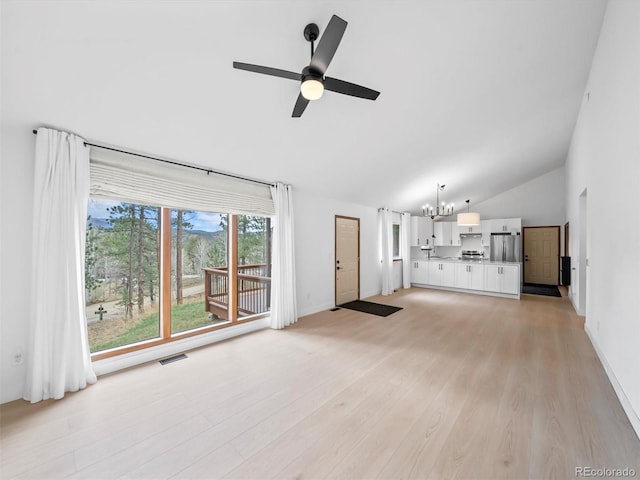 14 Aspen Dr, Bailey, CO 80421 - unfurnished living room with lofted ceiling, a ceiling fan, light wood finished floors, a chandelier, and baseboards