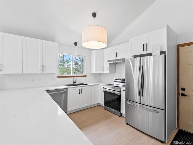 14 Aspen Dr, Bailey, CO 80421 - kitchen with stainless steel appliances, a sink, under cabinet range hood, vaulted ceiling, and white cabinets