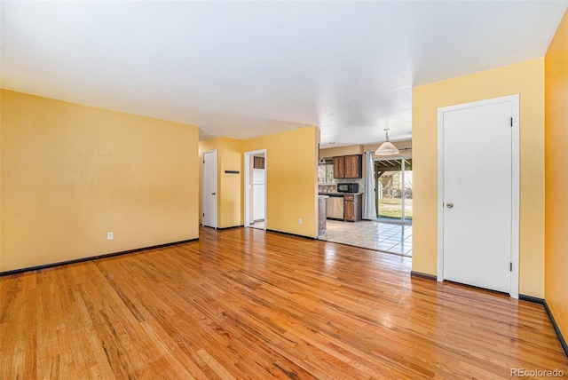 unfurnished living room featuring light wood-style floors and baseboards