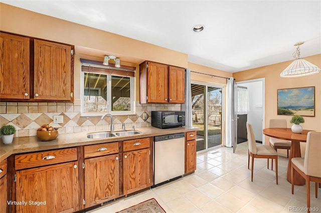 kitchen featuring dishwashing machine, brown cabinetry, a sink, black microwave, and tasteful backsplash