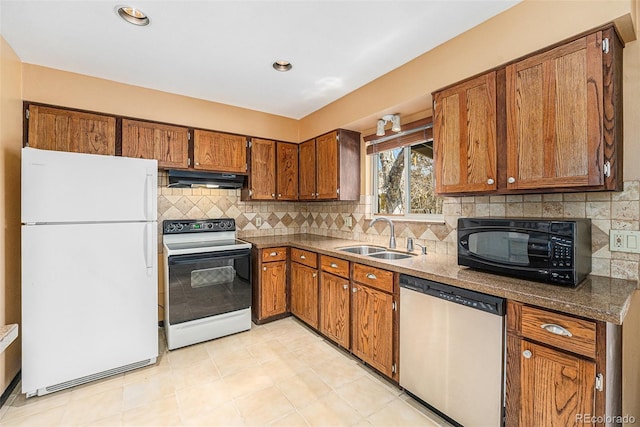 kitchen featuring ventilation hood, electric range oven, stainless steel dishwasher, freestanding refrigerator, and a sink