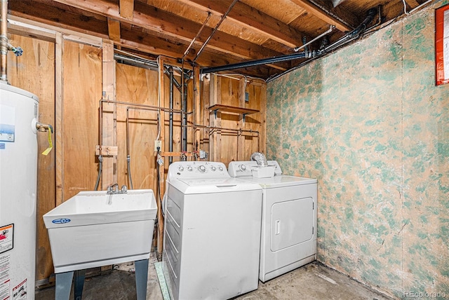 washroom featuring laundry area, independent washer and dryer, water heater, and a sink