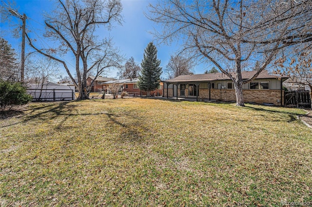 view of yard featuring a sunroom and fence