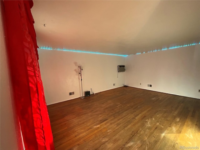 interior space with a wall mounted air conditioner and hardwood / wood-style floors