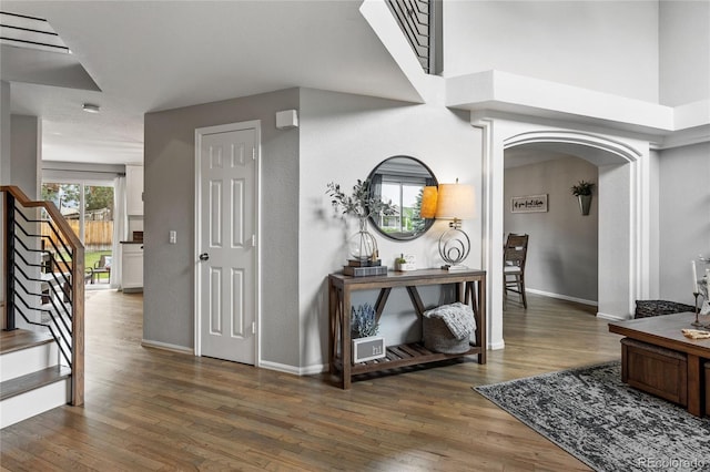 19935 E Stanford Dr, Centennial, CO 80015 - hallway with wood finished floors, stairway, arched walkways, and baseboards