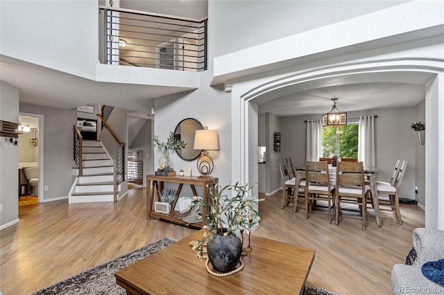 19935 E Stanford Dr, Centennial, CO 80015 - living room featuring arched walkways, light wood finished floors, stairway, and baseboards