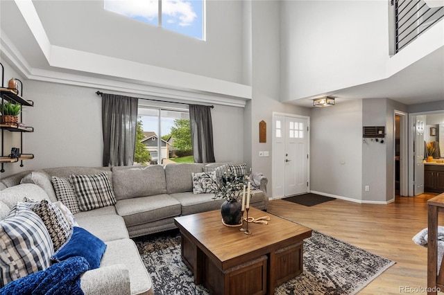 19935 E Stanford Dr, Centennial, CO 80015 - living area with light wood finished floors, a towering ceiling, and baseboards