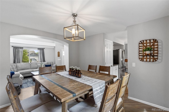 19935 E Stanford Dr, Centennial, CO 80015 - dining room with arched walkways, a chandelier, dark wood-style floors, and baseboards