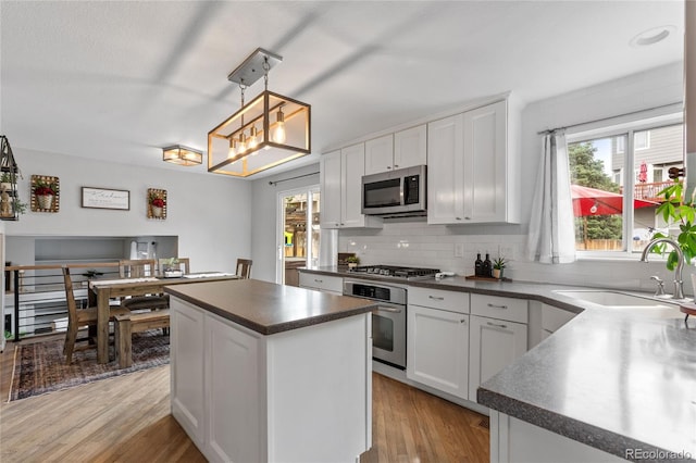 19935 E Stanford Dr, Centennial, CO 80015 - kitchen with stainless steel appliances, a sink, dark countertops, decorative backsplash, and a kitchen island