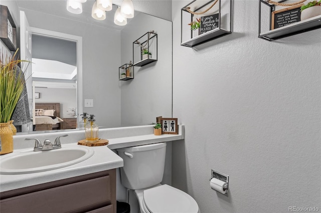 19935 E Stanford Dr, Centennial, CO 80015 - bathroom with vanity, toilet, connected bathroom, and a textured wall