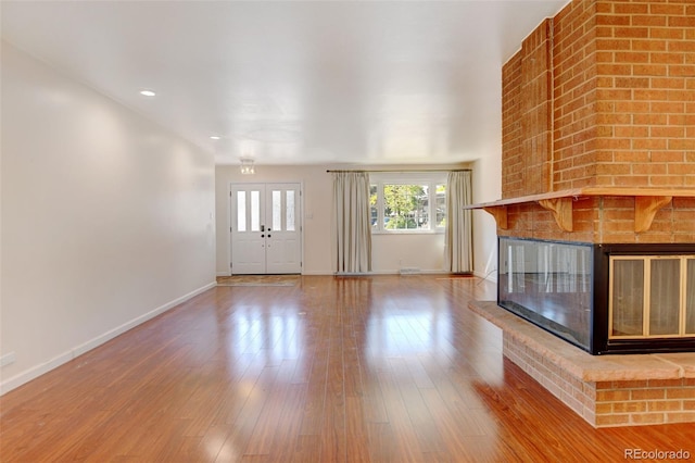 unfurnished living room featuring a fireplace and wood-type flooring