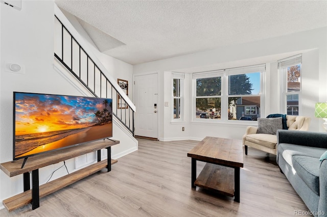 living room with light hardwood / wood-style floors and a textured ceiling